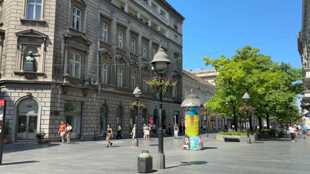 People walking along a sunny pedestrian street in central Belgrade, Serbia, lined with historic buildings and trees Things to Do in Belgrade: Pedestrian Street in the City Center